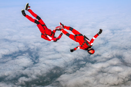Skydiving photo. Two sports parachutist build a figure in free fall. Extreme sport concept.の写真素材