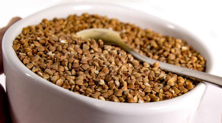 White bowl filled with buckwheat for cooking tasty and healthy porridge.の写真素材
