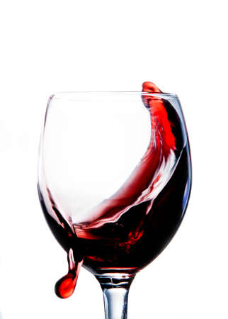 On a white background red wine. A drop of wine glides on a glossy the surface of the glass.の写真素材
