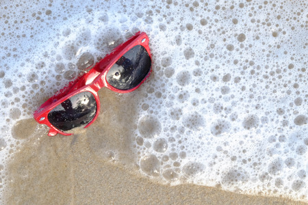 Red sunglasses on the sand at the beach, summer timeの写真素材