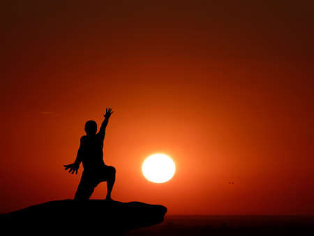 silhouette of a man at the top of the mountain against the skyの写真素材