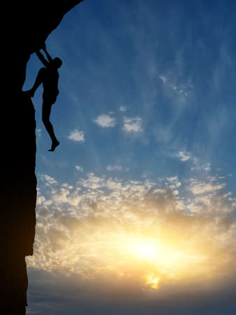 man on top of the mountain reaches for the sunの写真素材