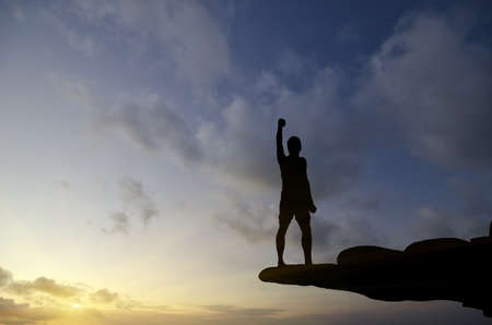 man on top of the mountain reaches for the sunの写真素材