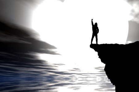 man on top of the mountain reaches for the sunの写真素材