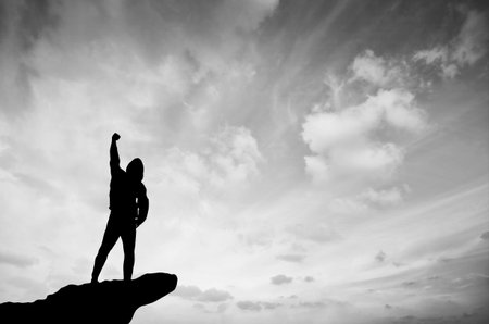 man on top of the mountain reaches for the sun