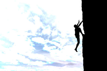 man on top of the mountain reaches for the sunの写真素材