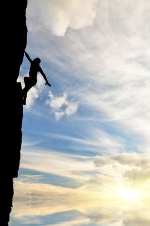 man on top of the mountain reaches for the sunの写真素材