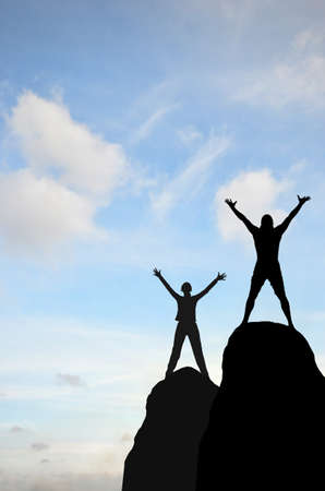 man and woman were placed on top of the hill hand in hand against the sunny skyの写真素材