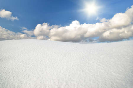 winter landscape against the backdrop of sunny sky with cloudsの写真素材