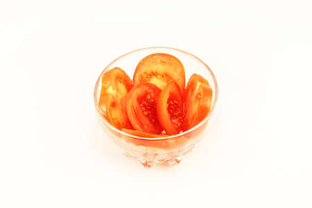 sliced tomatoes folded in a glass bowlの写真素材