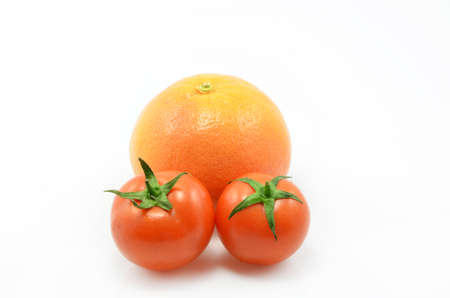grapefruit and two tomatoes on a white backgroundの写真素材