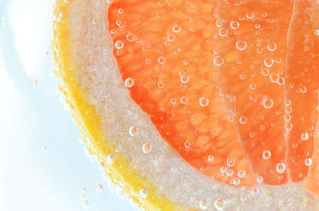 share of grapefruit immersed in a liquid with bubblesの写真素材