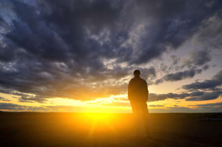 Silhouette of man at the sunset. Emotional scene.の写真素材