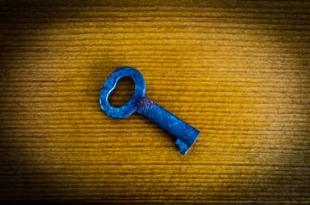 Antique Small Skeleton Key closeup on a woodgrain backgroundの写真素材