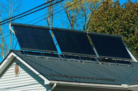 Horizontal orientation of a residential solar water heater installation against a clear blue sky and...