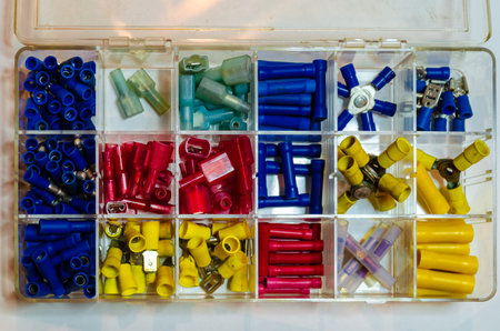 colored assorted wire crimp connectors in a plastic organizer on a white background