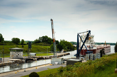 View of a Great Lakes Freight ship heading out of locks downward on the St. Lawrence River at...
