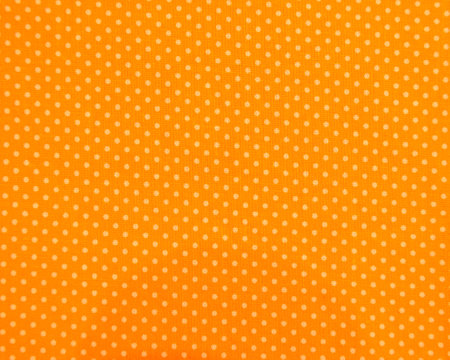Full frame close-up of orange and yellow polka dot fabric background above viewの写真素材