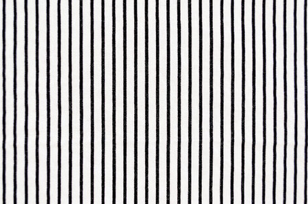 Close-up of whte fabric with vertical black stripes filling the frame for an abstract background