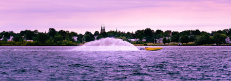 6 x 17 panorama of a speeding boat trailing a water plume showing motion under a morning pink sky...