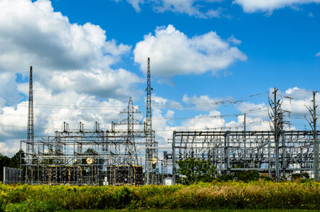 electrical sub-station in a field under a cloudy blue sky.