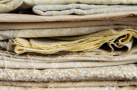 Close-up side view of a pile of folded brown fabric pieces filling the frameの写真素材