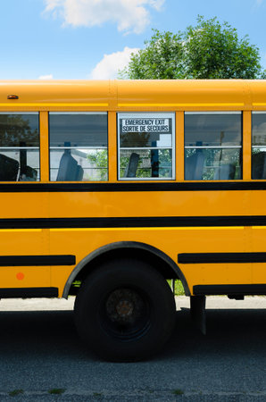 Emergency exit window on the side of a school bus above the rear wheel.