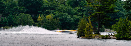 Panorama of a two blurred speedboats racing past each other between two islands on the St. Lawrence...