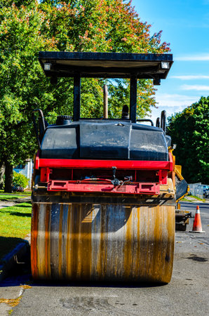 Rear close-up view of a compaction roller showing the lines of rust patterns, parked on a...
