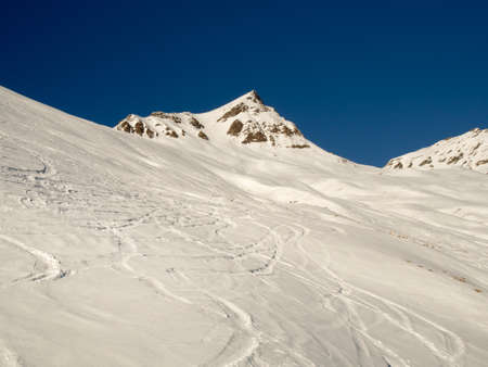Traces in the fresh snow on a mountain slopeの写真素材