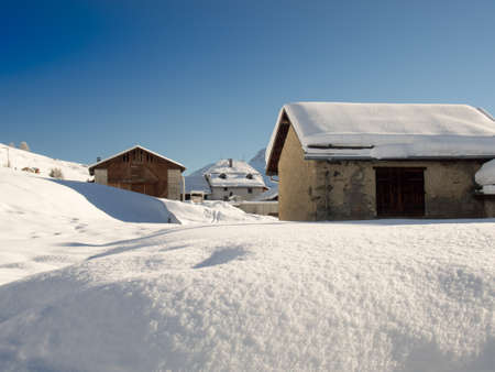 Fresh snow on farmhouses in the Engadine, Switzerlandの写真素材