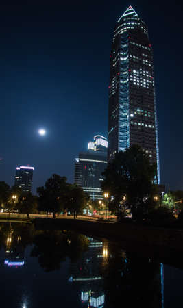 Trade Fair Tower, Messeturm, and full moon in Frankfurt, Germanyの写真素材