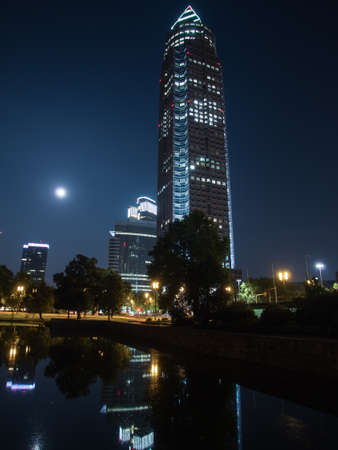 Trade Fair Tower, Messeturm, and full moon in Frankfurt, Germanyの写真素材