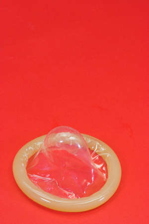 Condom on red background, aids preventionの写真素材