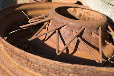 Rusted old wheel lying in scrapyard, sold as junkの写真素材
