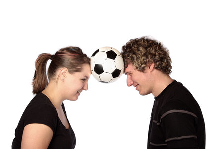 Couple with soccer ball between their headsの写真素材