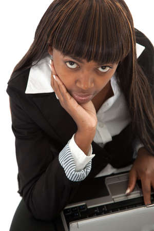 Young black female lawyer with face in hand on laptop looking upの写真素材