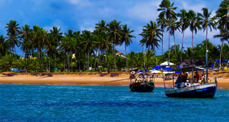 beach and sea with fishing boats going to sea の写真素材