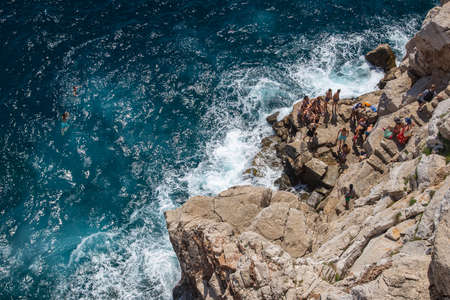Tourists and swimmers on the cliffs of Dubrovnik, Croatiaの写真素材