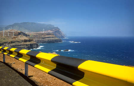 Madeira cliff with wind turbines and guard railの写真素材