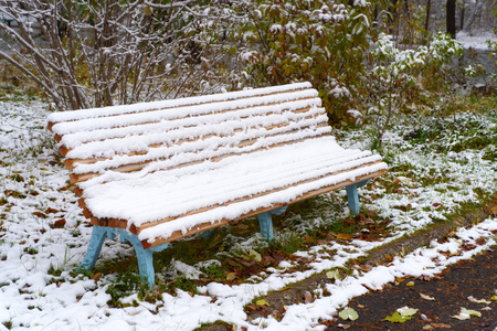 Autumn Scenery: Old Garden Bench in Late Fall Covered by First Snow. Shoot in Octoberの写真素材