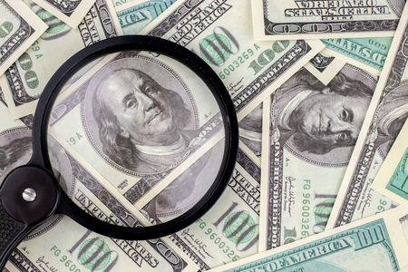 Magnifying glass on 100 dollar bill backgroundの写真素材