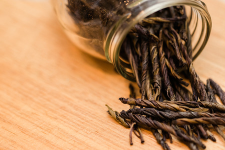 Dried black tea leaves in jar on the table close upの写真素材