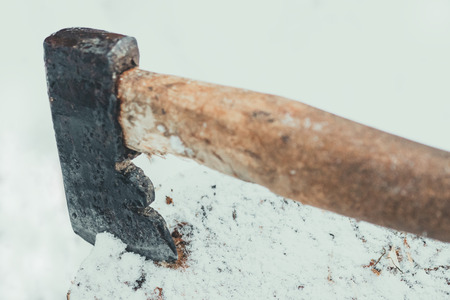 Axe in a log on snowの写真素材