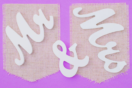 Wooden letters mr and mrs painted with white paint on violet background.の写真素材