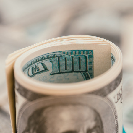 Roll of hundred dollar banknotes close-upの写真素材