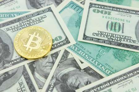 Golden bitcoin on dollar bills background