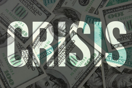 Crisis text on dollar bills background. Concept of financial crisesの写真素材