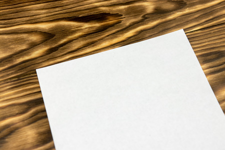 Close-up of sheet of white paper mockup on wooden backgroundの写真素材