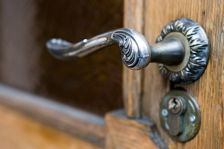 Metal handle close-up. Wooden doorの写真素材